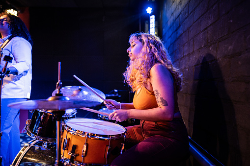 Young woman playing drum kit on a show