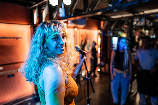 Portrait of a singer young woman on a pub (or stand-up comedy show)