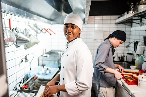 Portrait of a chef young man making a sandwich on a commercial kitchen