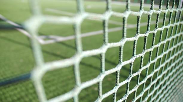 istock Green Football Pitch Seen Through a Net Rack Focus 1668002112