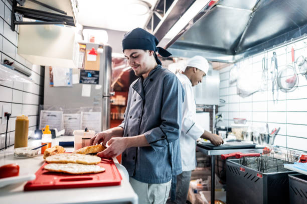 istock Chef young man making a sandwich on a commercial kitchen 1668003719