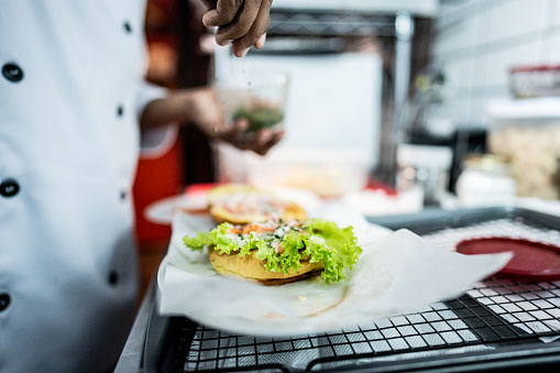 Close-up of a man making a sandwich on a commercial kitchen