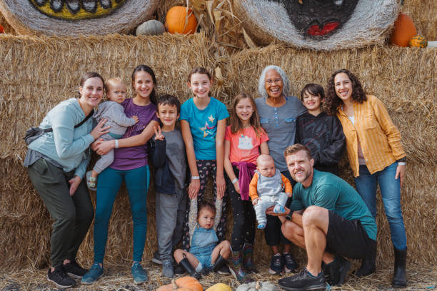 famiglia multigenerazionale posa per una foto in un campo di zucca - 12 23 mesi foto e immagini stock