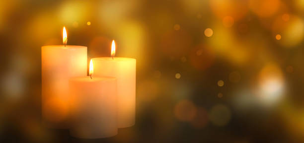 istock three white burning candlelights isolated on blurred abstract background with golden bokeh lights, advent season decoration in warm atmosphere 1668014825