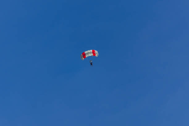 Parachutist silhouette against dramatic cloud sky. Sport, hobby background