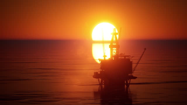 Oil drilling platform   at sunset