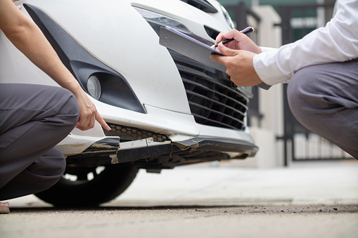 Insurance agents meet with customers when accidents occur to inspect damage and document insurance claims expeditiously. concept of car insurance agents to urgently inspect damage for customers.