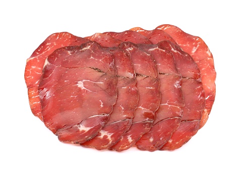 Slices of Bresaola della Valtellina, bottom sirloin cut, on white background.