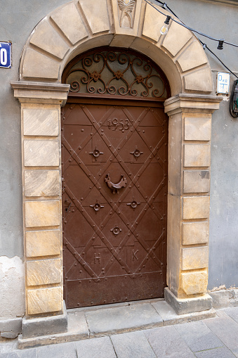 Old doors in the house. Entrance to the building. Forged metal gratings. Poland, Warsaw - July 27, 2023.