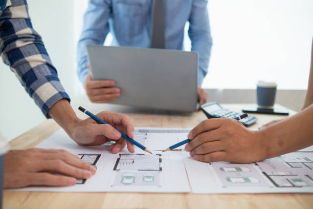 istock Construction engineers discuss and exchange ideas with architects to improve house plans to meet customer needs. A concept for exchange of design ideas between construction engineers and architects. 1668122250