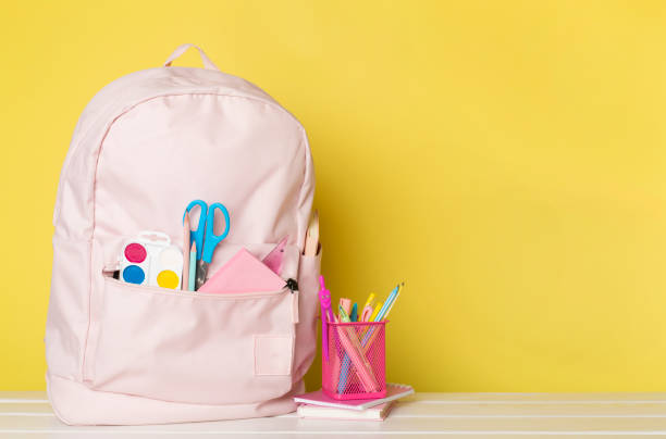 istock Pink school backpack with stationery on wooden table 1668138114