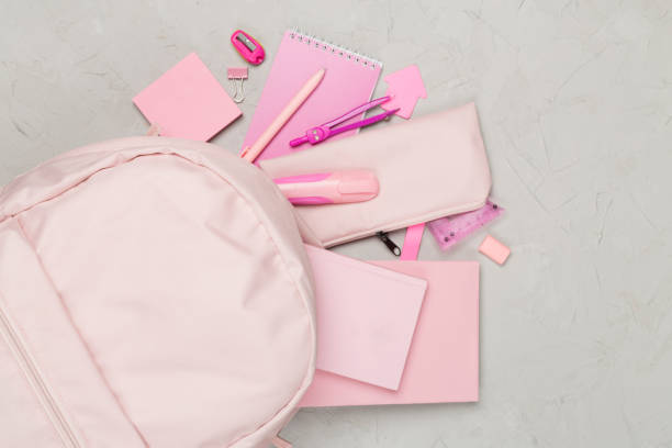 istock Pink school backpack with stationery on concrete background, top view 1668138125