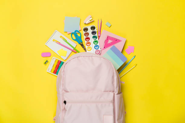 istock Pink school backpack with stationery on color background, top view 1668138345