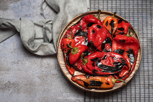 Ground dry red pepper on stone board with fresh chili on background. Closeup