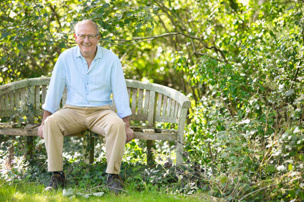 istock Senior man sitting on an old bench in his garden 1668214425
