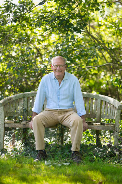 istock Senior man sitting on an old bench in his garden 1668215171