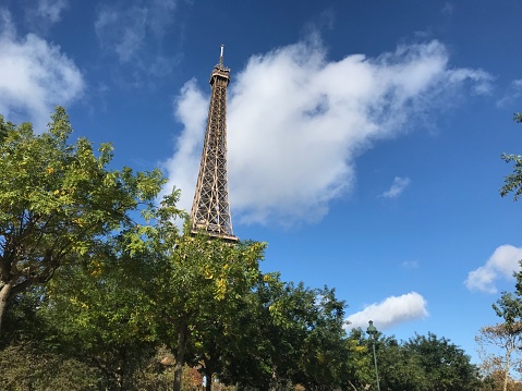 Paris, France - September 06, 2019. The Eiffel Tower on the Champ de Mars. People enjoying sunny day at the public place.