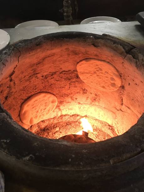 istock Traditional Tandoori Oven Baking Naan Bread 1668310745