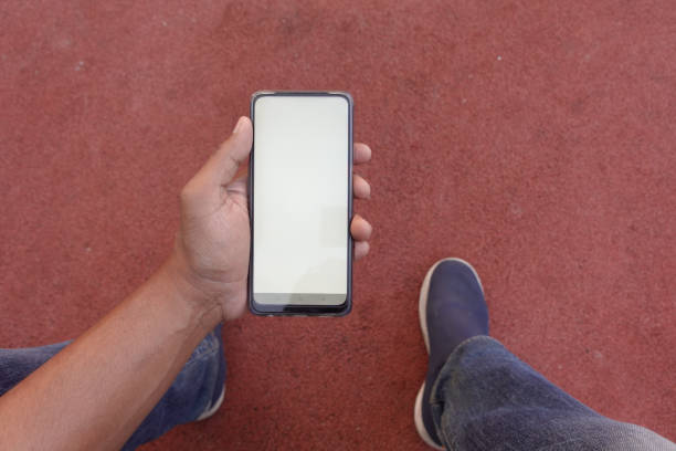 istock pov shot of young man hand using smart phone with empty screen sitting on park 1668332423