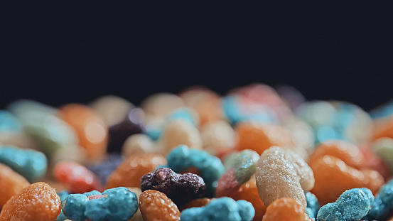 Macro shot of colorful  colorful fruit cereal  rotating  in a bowl with milk