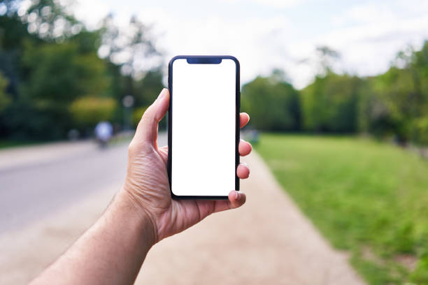 istock Man holding smartphone showing white blank screen at park 1668351568