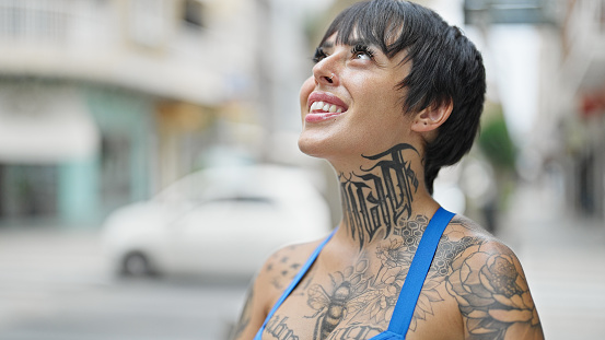 Young beautiful hispanic woman smiling confident looking to the sky at street