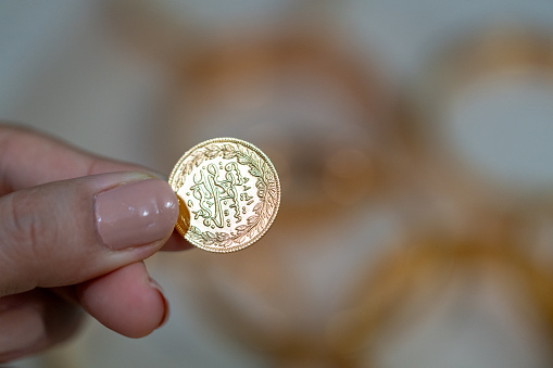 Hand holding Turkish gold coin, gold , hand