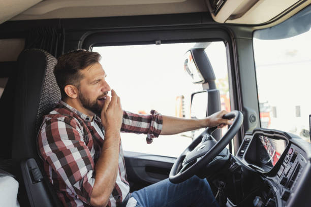 istock Male Driver Yawning While Driving a Truck 1668409278