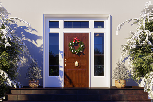 House Front Door With Christmas Wreath And Snowy Fir Trees