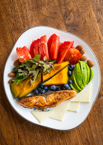 Low carb / low calorie meals consist of tomato, garden greens, steamed squash, blueberries, cheese, and pan grilled salmon.