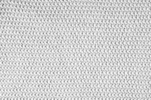 Knitted background.Texture of coarse horizontal knitting from white woolen threads.