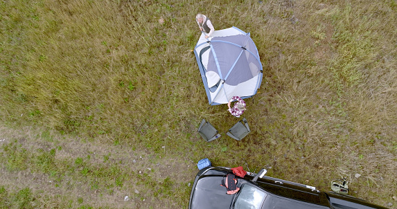 They have parked their vehicle in the meadow and are relaxing in a tent, Crowsnest Pass, Alberta