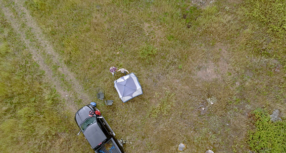 They have parked their vehicle in the meadow and are relaxing in a tent, Crowsnest Pass, Alberta