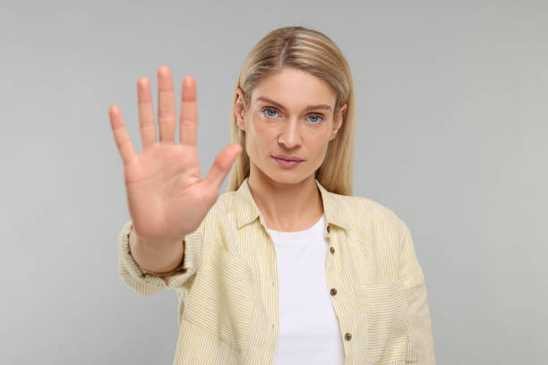 istock Woman showing stop gesture on grey background 1668576163
