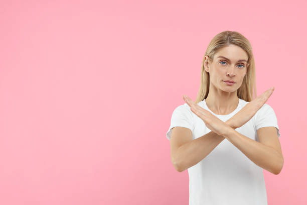 istock Stop gesture. Woman with crossed hands on pink background, space for text 1668576485