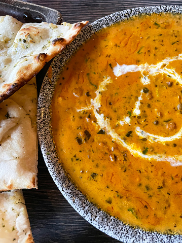 Stock photo showing close-up, elevated view of Dal makhani curry and pilau rice in serving bowls as part of Indian meal in a restaurant.