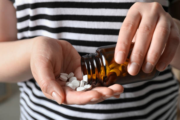 istock Woman pouring pills from bottle, closeup view 1668592974
