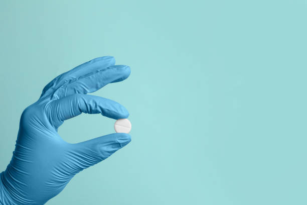 istock Doctor holding pill on turquoise background, closeup. Space for text 1668593484