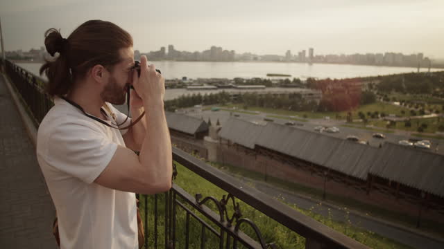 Male traveler taking photo of cityscape during trip