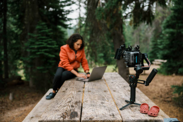 istock Female freelancer in media production working remotely in forested campground 1668772994
