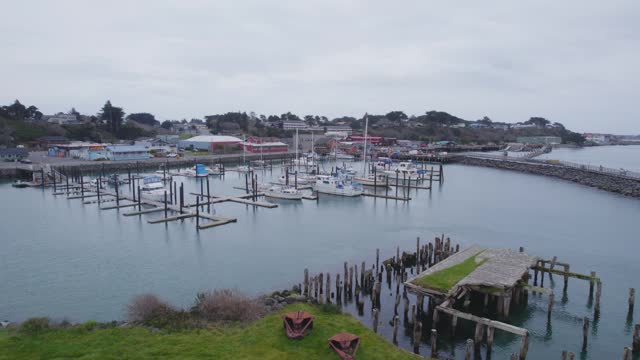 Aerial reverse dolly around nearly empty harbor in Bandon Oregon
