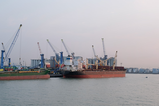 Container cargo ship with crane bridge with import-export logistics and transportation industry in Surabaya on July 27 2023