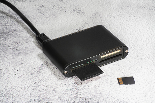 Black USB multiformat memory card reader on a grey background