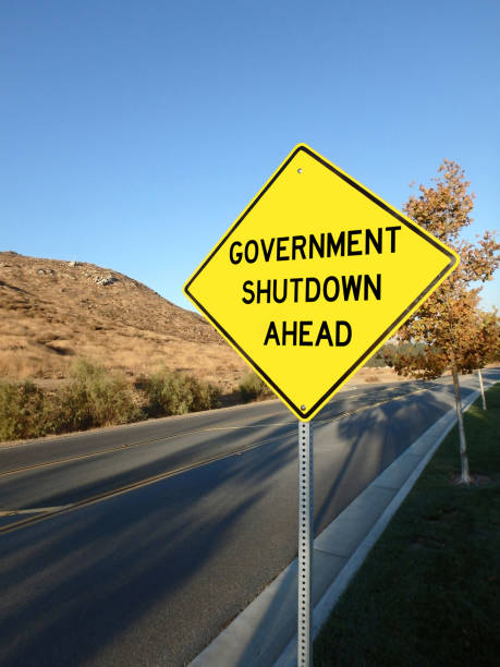 istock Yellow roadside warning sign reading government shutdown ahead warning 1669036687