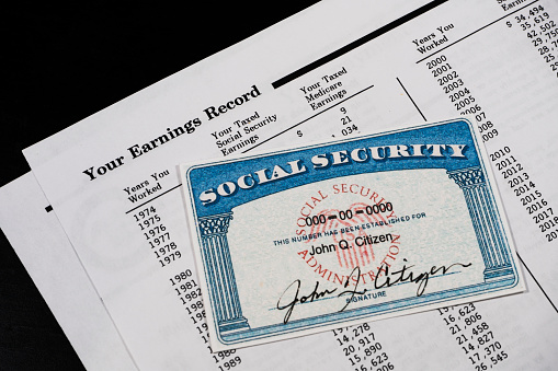 Fake social security card with SSA earnings record statement on black background. Concept of retirement planning.