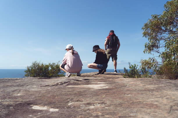 padre y dos hijas mirando un hermoso paisaje marino, australia - australian culture hiking australia people fotografías e imágenes de stock