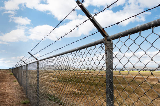 istock A long chain link fence with barbed wire stretches into istance 1669038825