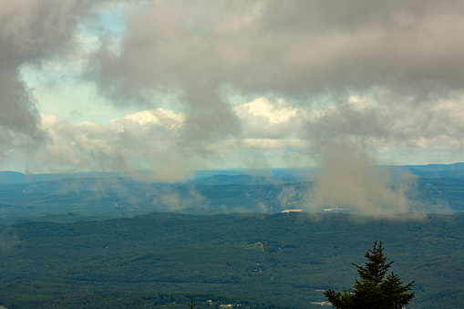 Passing dark rain clouds floating by, seen from the summit of Mt. Kearsarge, at Winslow State Park in Wilmot, New Hampshire