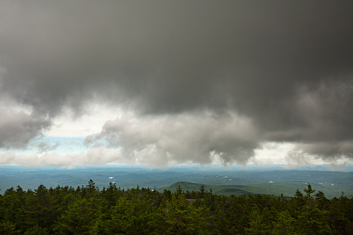 Passing dark rain cloud floating by, seen from the summit of Mt. Kearsarge, at Winslow State Park in Wilmot, New Hampshire