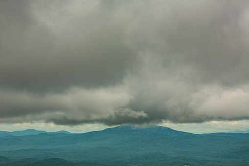 Passing dark rain cloud floating over Mt. Cardigan, seen from the summit of Mt. Kearsarge, at Winslow State Park in Wilmot, New Hampshire